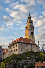 Golden illuminated building of tower and castle, sunset, Cesky Krumlov.