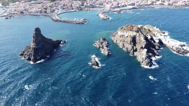 View from the sea to Cyclops Riviera and Mount Etna