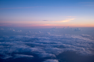 Beautiful view of cumulus clouds with sunrise at atmosphere from airplane window, sunset sunrise from airplane window