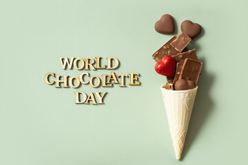 World chocolate day text with chocolate flat lay, top view on pastel green background
