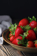 A bowl with ripe bright strawberry in rustic style	