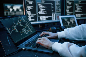 Side close up view of female hacker hands, typing on keyboard