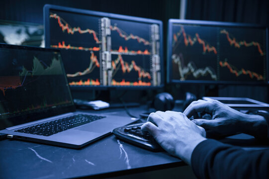 Financial Analyst Working on a Computer with Multi-Monitor Workstation with Real-Time Stocks, Commodities and Exchange Market Charts