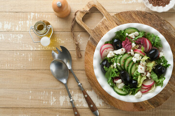 Lettuce salad, cucumber, radish salad with cottage cheese and flax seeds olive oil salad on old wooden background. Healthy diet food. Diet menu and balanced diet. Top view.
