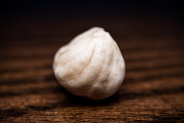 close-up and front shot of hazelnut on wooden table, detailed shot of hazelnut on table on black background
