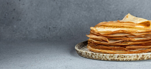 Thin crepes on a plate. Delicious breakfast or dessert. Long banner format. top view
