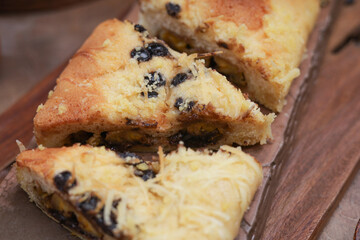 Sweet bread with banana and chocolate filling, topped with chocolate chips, bakery product