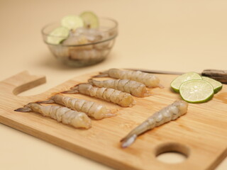 Raw prawns on wooden chopping board, ingredients for cooking