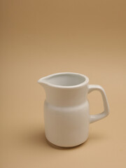 Pitcher or milk jug, isolated on beige background