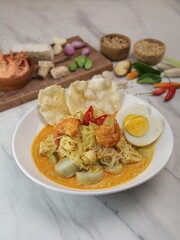 Rice cakes and vegetables curry served with boiled egg, prawn and rice cracker. Indonesian traditional cuisine from Sumatra.