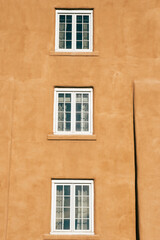 Fototapeta na wymiar White windows on Adobe style building