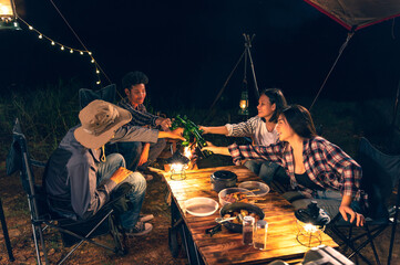 Asian LGBTQ+ couple drinking and barbecue in a romantic camping setting. Groups of friends and...