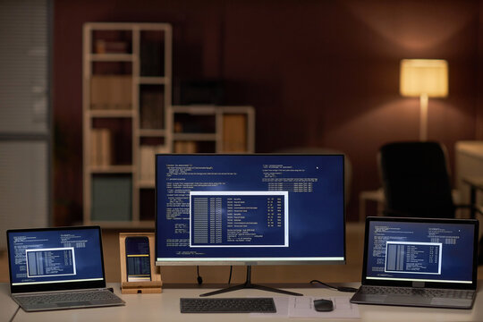 Close-up of computer monitors with program codes in IT office