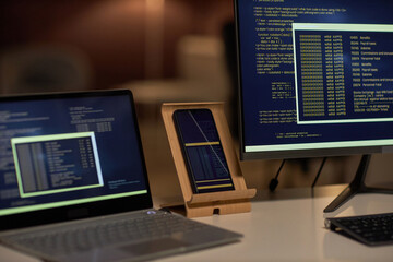 Close-up of computers with codes for new software on monitors standing on workplace of developer