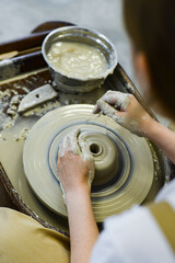 Fototapeta premium close up view of professional potter working on pottery wheel at workshop. High quality photo