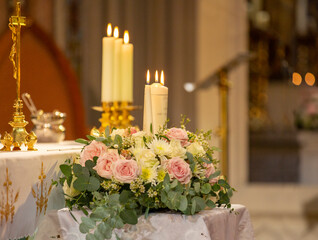 burning candles on an altar with flowers