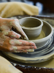 close up view of professional potter working on pottery wheel at workshop. High quality photo