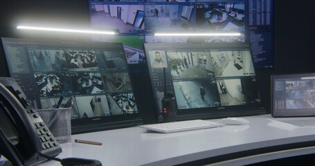 Computer monitors and tablet showing video footage of surveillance cameras with AI facial recognition system. Big digital screen on the wall on background. Modern security control center. Timelapse.