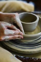close up view of professional potter working on pottery wheel at workshop. High quality photo