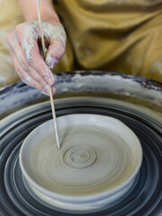Fototapeta na wymiar close up view of professional potter working on pottery wheel at workshop. High quality photo