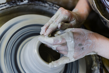 close up view of professional potter working on pottery wheel at workshop. High quality photo