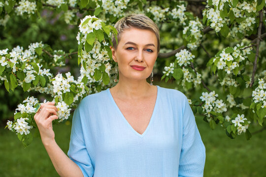 Portrait of a young blonde girl posing in spring park