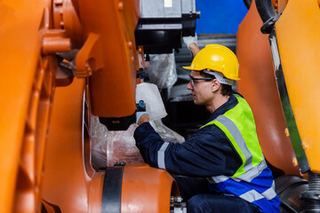 Male technician engineer checking automation robotics arm at industrial modern factory. man working at factory innovation automation robot.