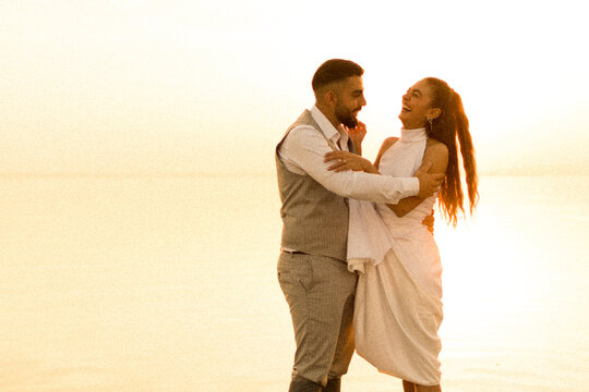 Loving Couple Enjoy Sunset Standing In Shallow Lake Water