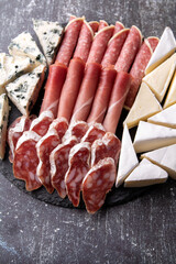 photo different kinds of sausage and cheese sliced on a round plate