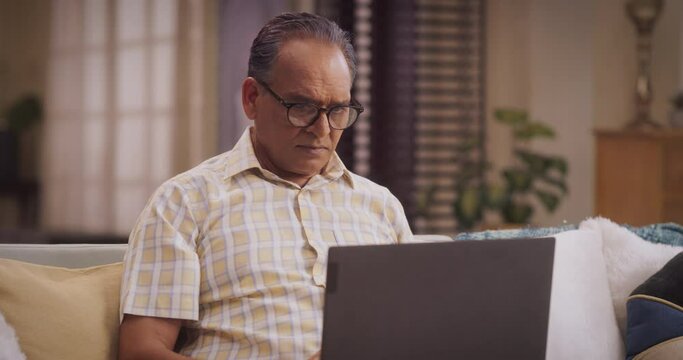 Indian Man Using Laptop: Exciting Online Adventures, Broadening Horizons, Sparking Joy Through Digital Exploration. Engaging And Connecting With People Sharing Interests.  Medium Close-up Arc Shot.