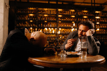 Friends toasting each other with shots of vodka as they enjoy a relaxing night out together at the pub