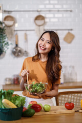 Young Asian woman is preparing a fresh healthy vegan salad with many vegetables in the kitchen, Dieting Concept. Healthy food Lifestyle. Cooking At Home.