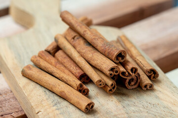 Cinnamon sticks on a wooden coaster on a wooden background