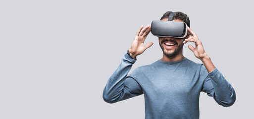 Young man using virtual reality headset isolated over gray background, VR, future, gadgets,...