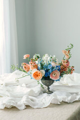 Still life of Flowers bouquet in vintage vase on white linen French tablecloth