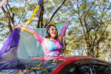 Happy Asian woman support LGBT pride parade in car. with Rainbow of LGBTQ or LGBTQIA.