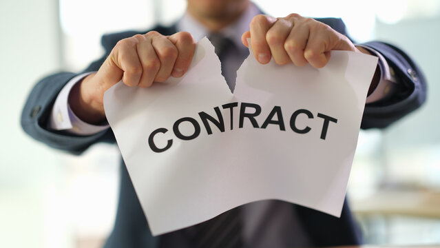Businessman in suit tearing up job contract in office closeup. Termination of contracts and transactions concept