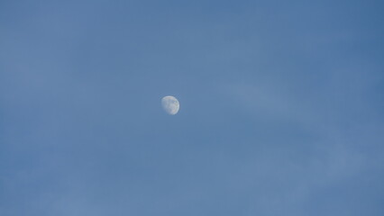 The blue sky view with the curve white moon in the sky in the day