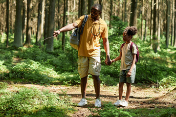 Dad teaching his daughter to active recreation, they going camping in the forest