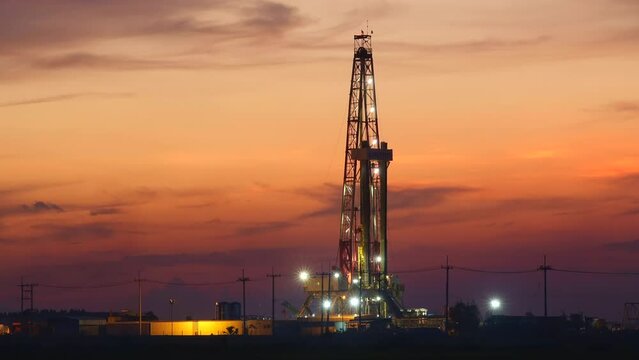 Sunset oil drilling rig in the field Time lapse