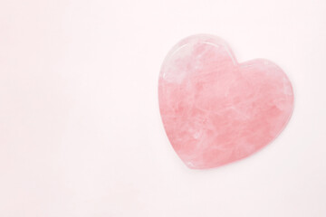 Isolated light rose quartz heart of stone. Pink gemstone heart