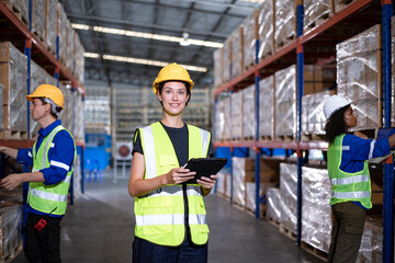 Male and Female inspector workers wearing helmets in logistics distribution warehouse. Group of diversity warehouse worker meeting and checking list inventory in industry factory.
