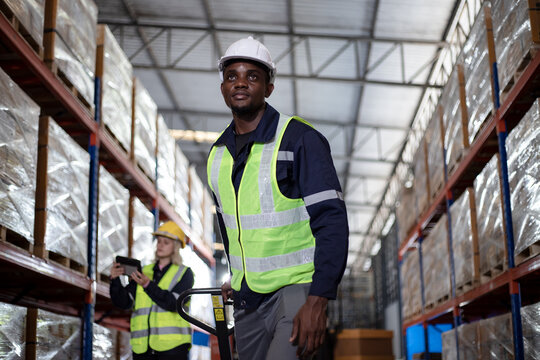 African-american male worker looking away in warehouse. Freight transportation and distribution warehouse with assistants. Logistics and cargo