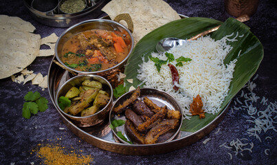 South Indian vegan thali  on banana leaf, sambar, vegetable curry, rice