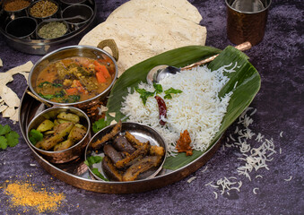 South Indian vegan thali  on banana leaf, sambar, vegetable curry, rice
