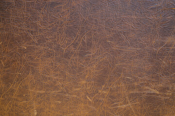 Fototapeta na wymiar Cracked brown leather as a vintage background