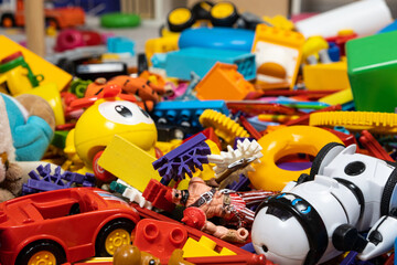 An abundance of toys in the children's room, a lot of plastic multi-colored parts from designers, spare parts for toys, figurines and cubes. - obrazy, fototapety, plakaty