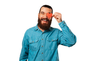 Fototapeta premium Wide smiling bearded man wearing blue shirt is holding a heart shaped paper over his eye.