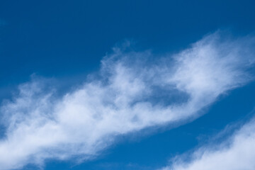 fluffy cirrus clouds in the blue sky. 