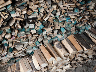 Dry firewood stacked in a pile, chopped wood for winter heating fuel of the fireplace. Natural wood background.